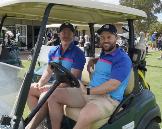 Two people in a golf cart smiling Two people in a golf cart smiling